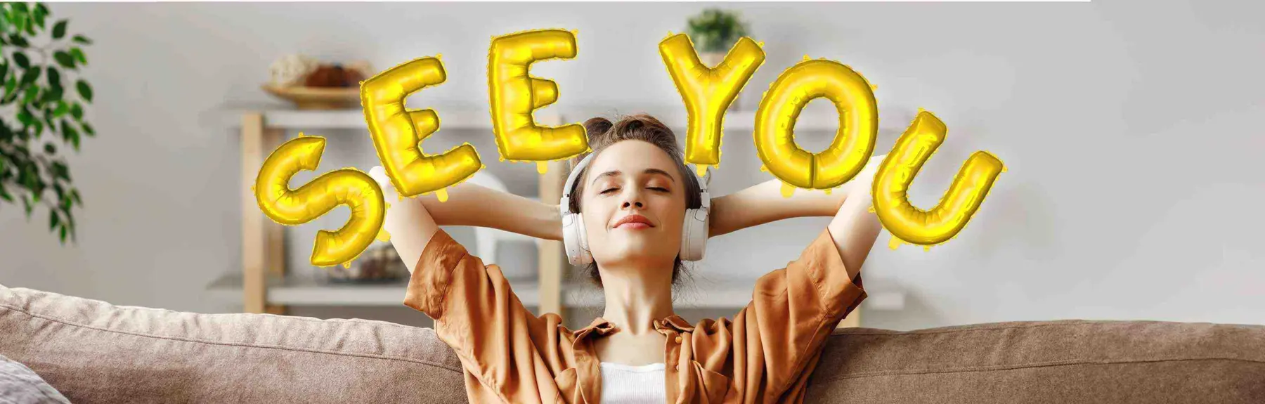 A relaxed young woman with her hands behind her head and headphones on a sofa. Around her head is the lettering "See you" in the form of golden balloons.