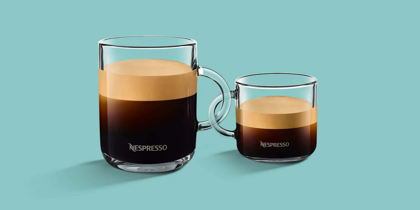 Zwei unterschiedlich große Gläser mit Nespresso, deren Henkel ineinander verschränkt sind