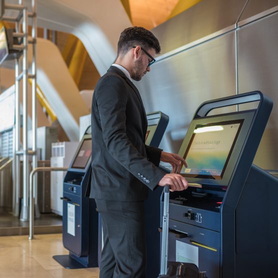 A man in a suit operates a check-in terminal